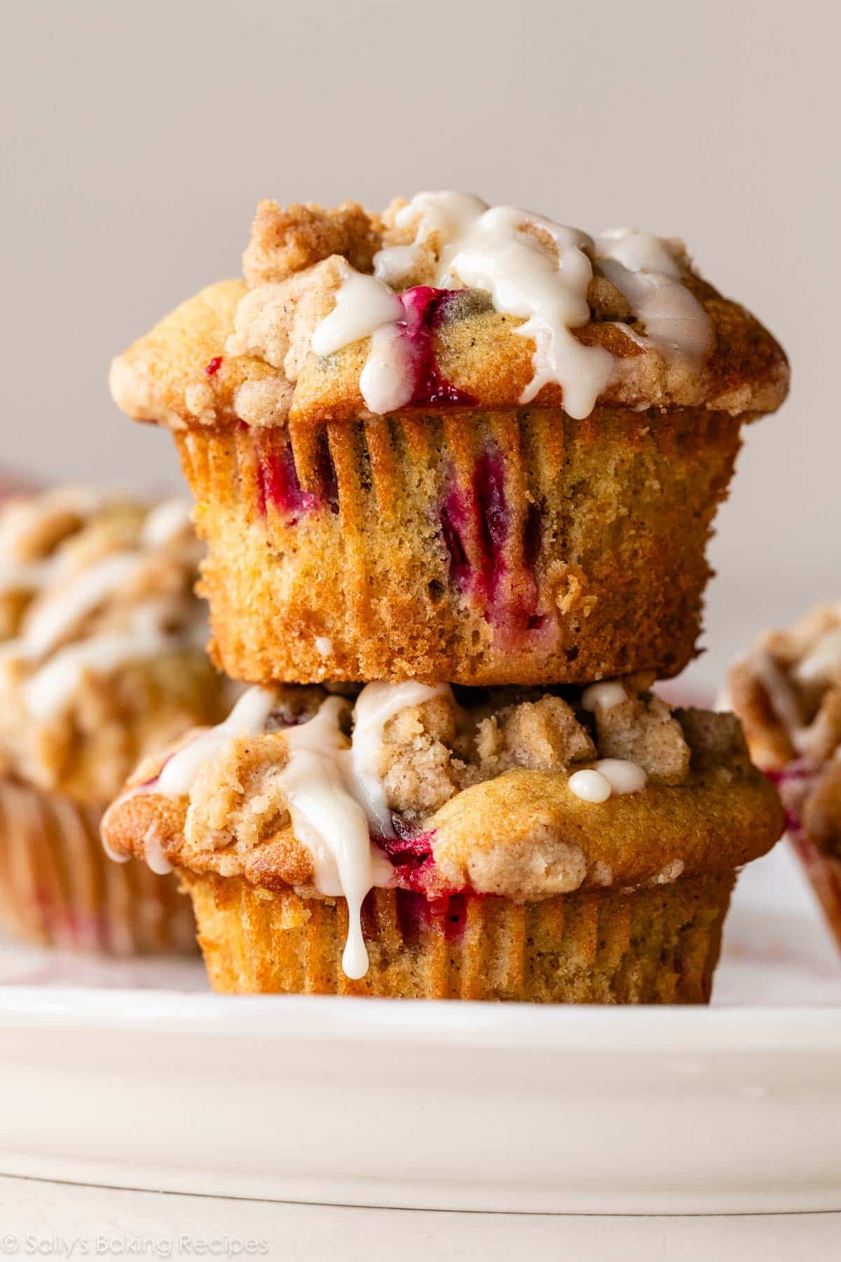 pile de 2 muffins à l'orange et aux canneberges avec glaçage sur le dessus.