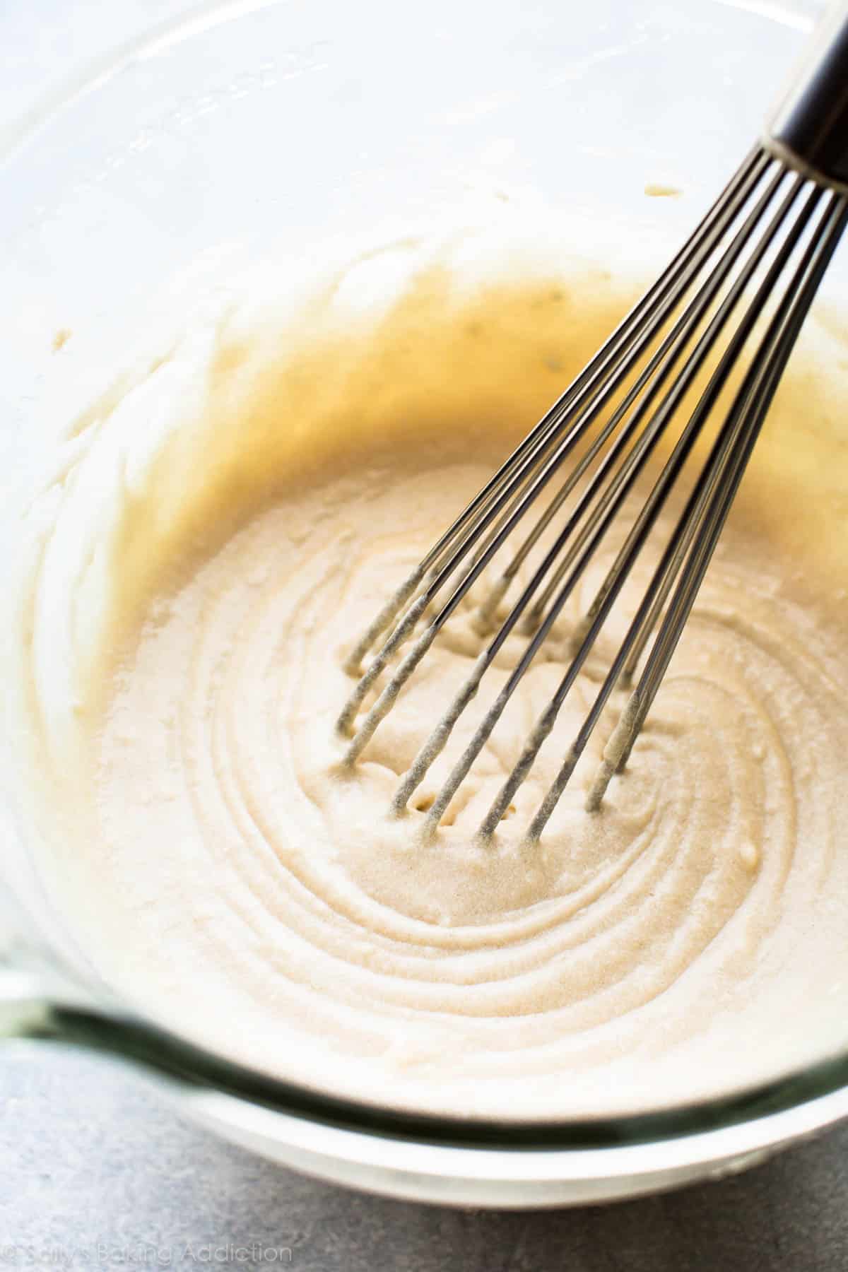 batter vanille dans un bol en verre avec un fouet en métal