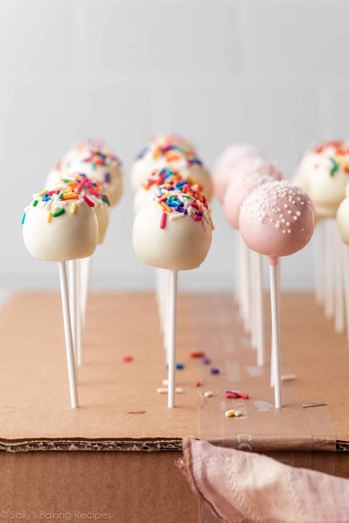 cake pops avec un enrobage blanc et un enrobage rose clair.