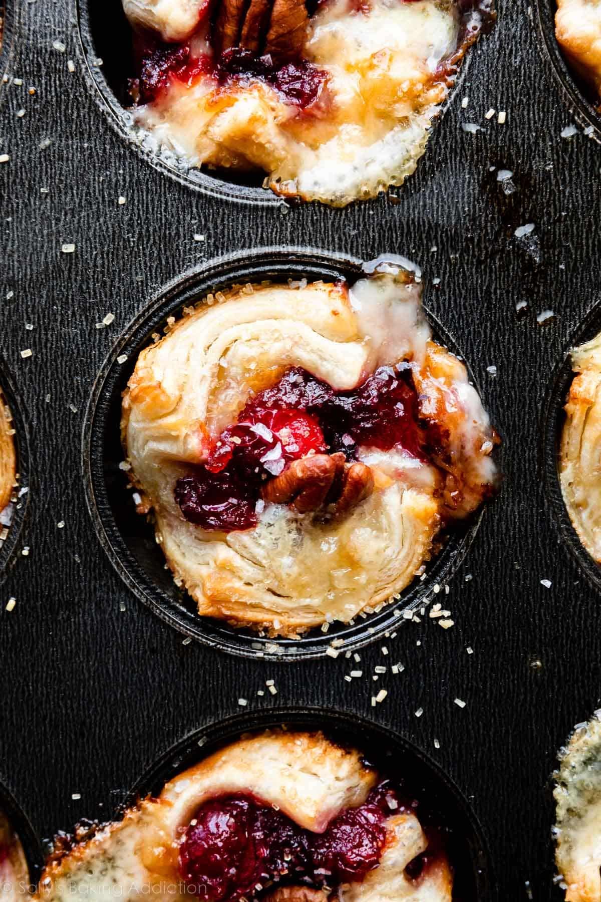 tartelettes de sauce cranberry et brie dans un moule à muffins.