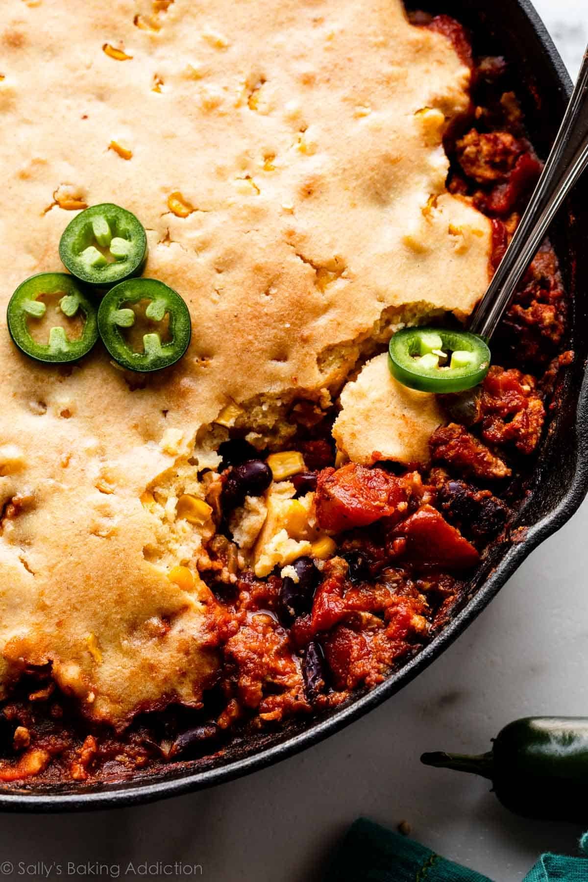 casserole de chili au pain de maïs dans une poêle en fonte garnie de jalapeño tranché.