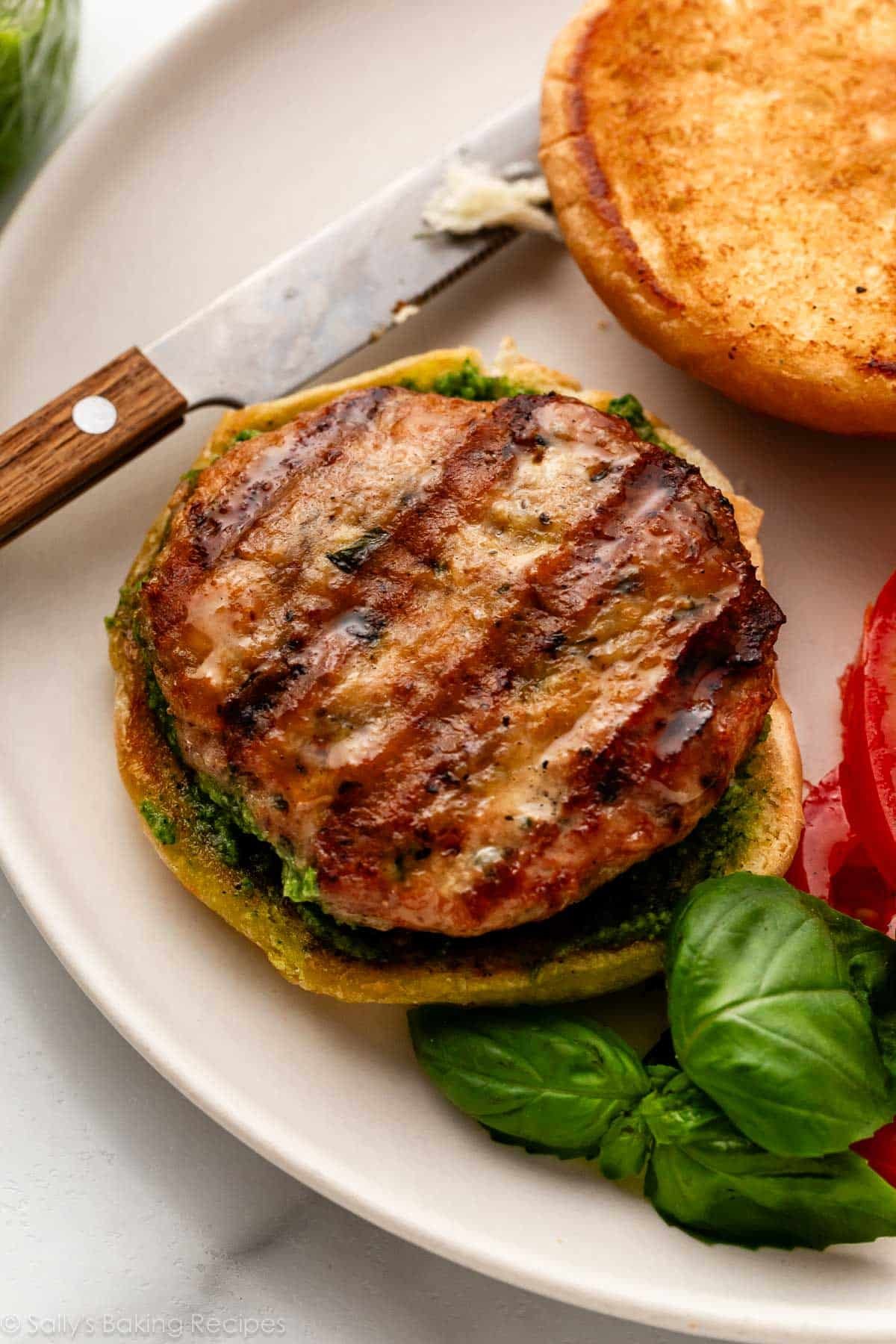 burger de poulet sur un pain avec basilic frais à côté.