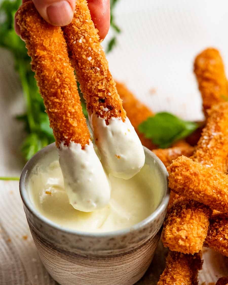 Trempage des frites de halloumi dans une sauce à l'ail