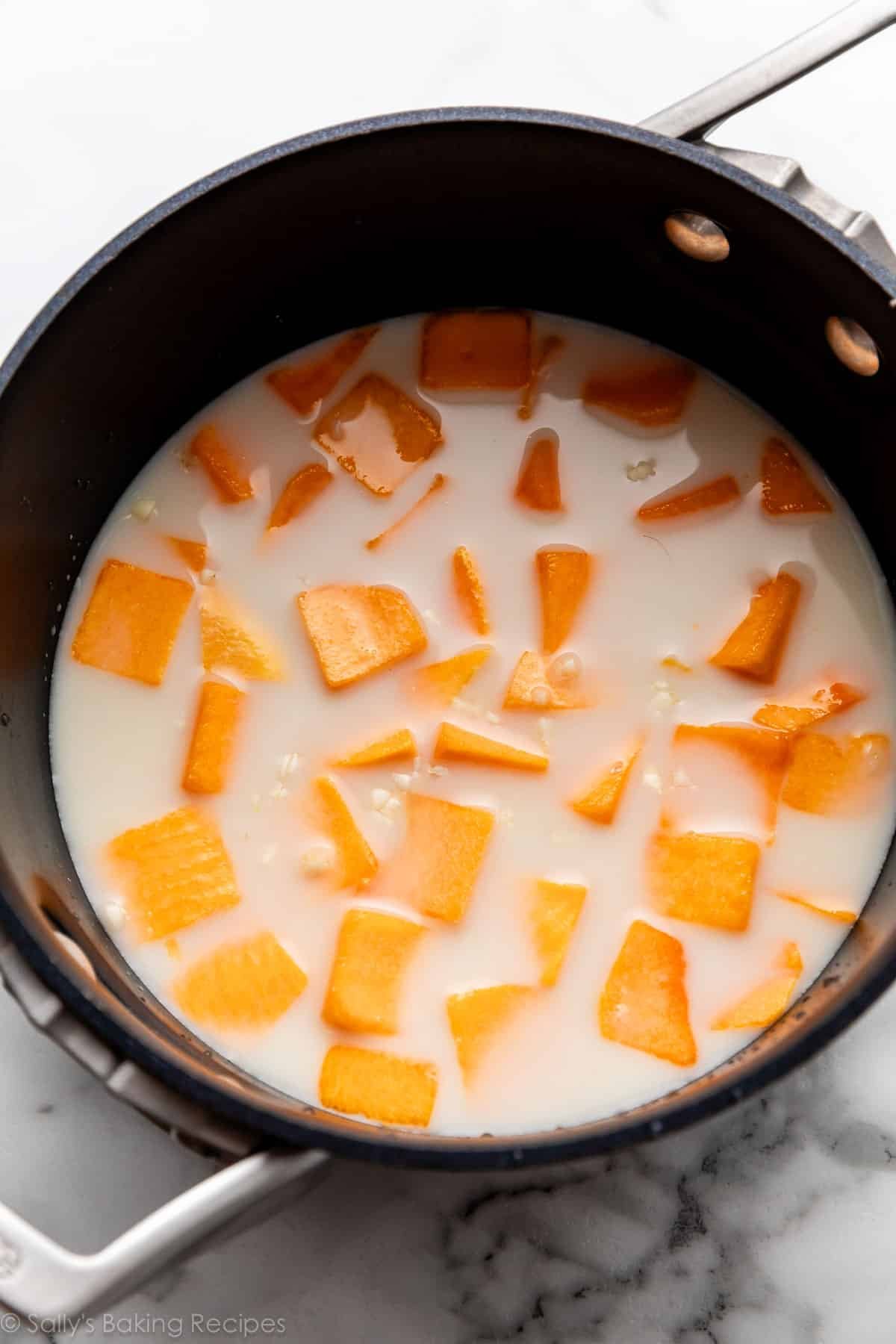 découpes de courge flottant dans du lait dans une casserole.