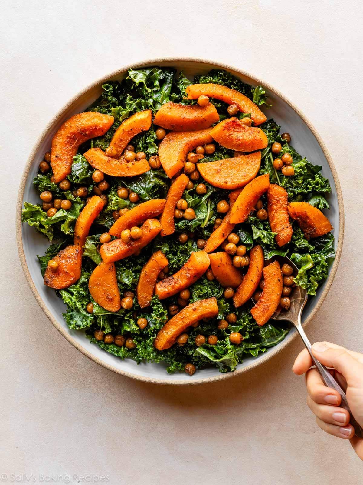 courge rôtie tranchée mise sur du kale.