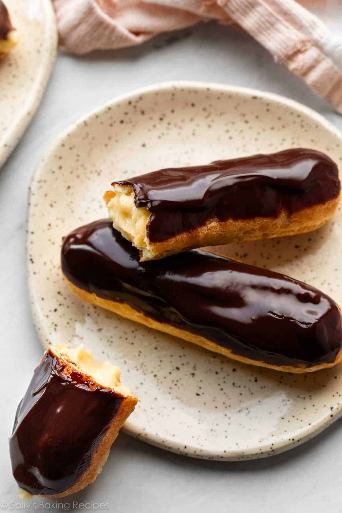 deux éclairs sur une assiette avec un déjà mangé.