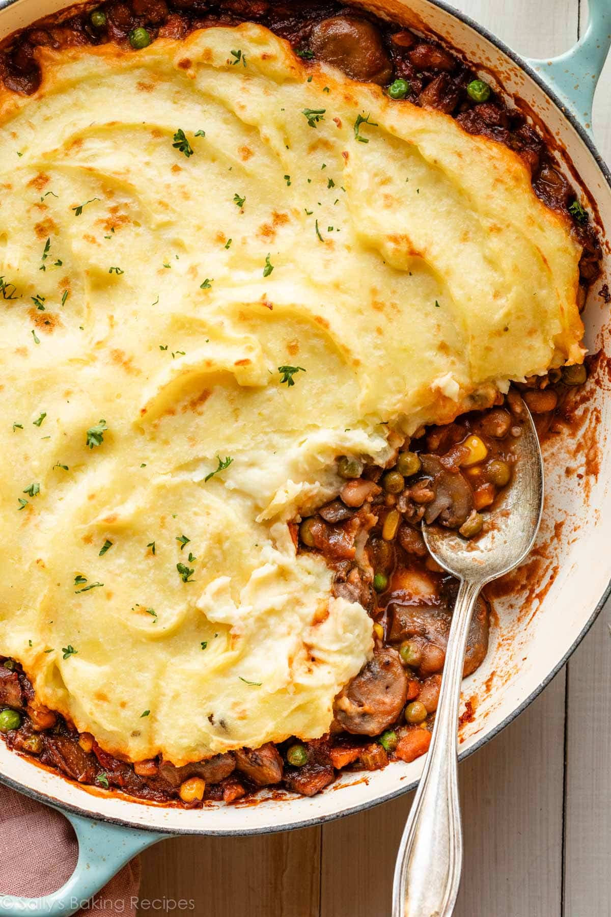 cuillère dans un plat de hachi-parmentier végétarien avec garniture de pommes de terre.