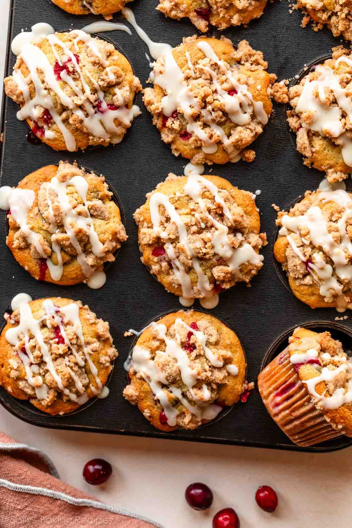 muffins à l'orange et aux canneberges avec garniture de crumble dans un moule à muffins.