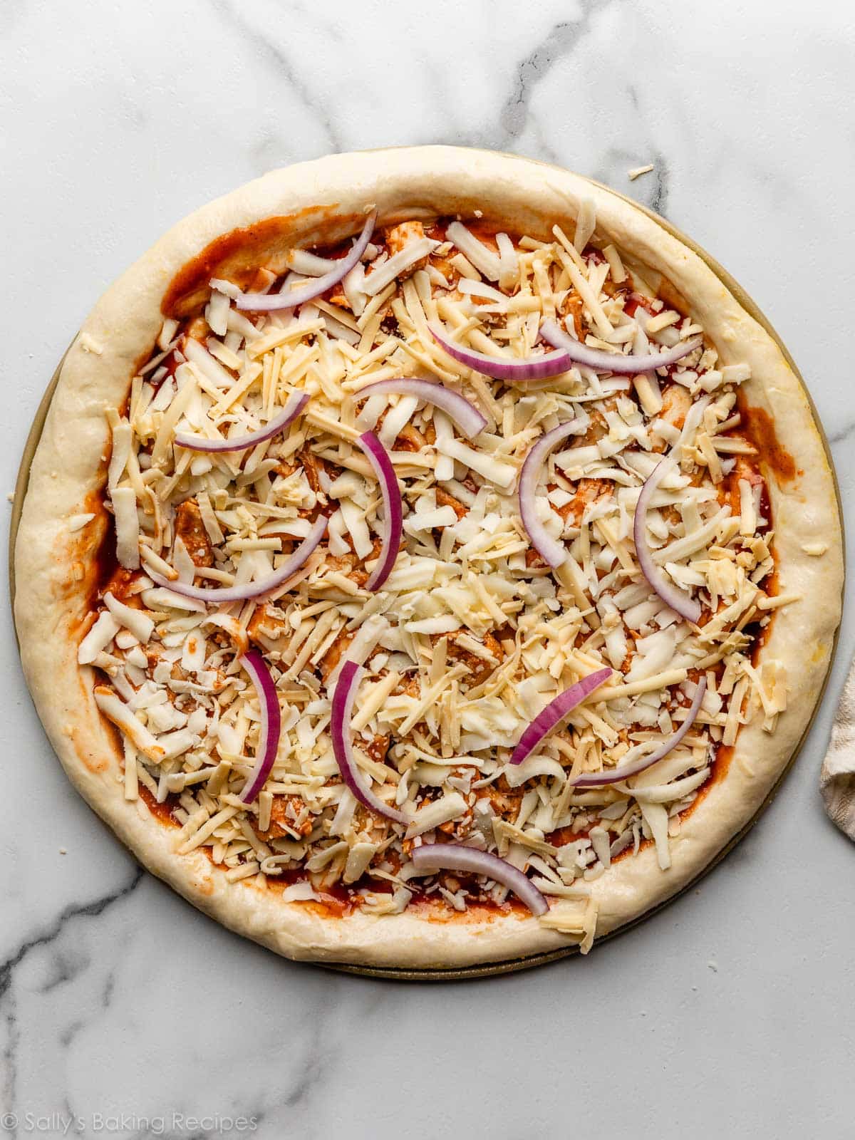 pizza au fromage et oignon assemblée avant la cuisson.