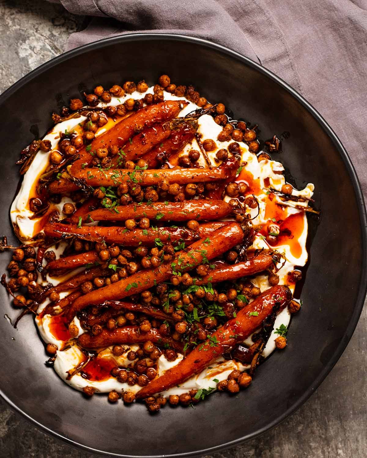 Carottes rôties à l'érable épicées avec pois chiches croustillants et sauce au yaourt prêtes à être servies