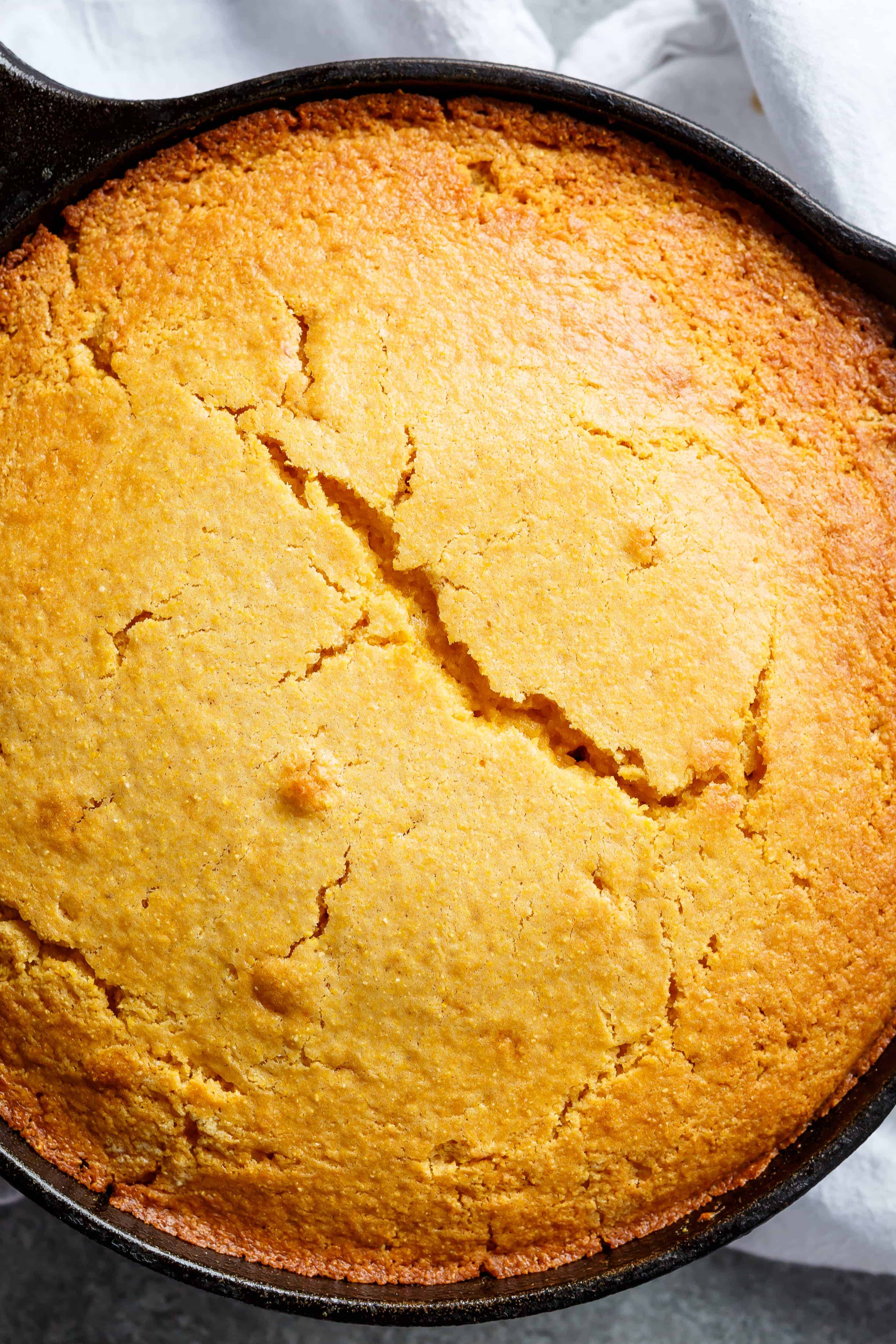 Vue du dessus du pain de maïs au babeurre croustillant cuit à la perfection dorée dans une poêle.