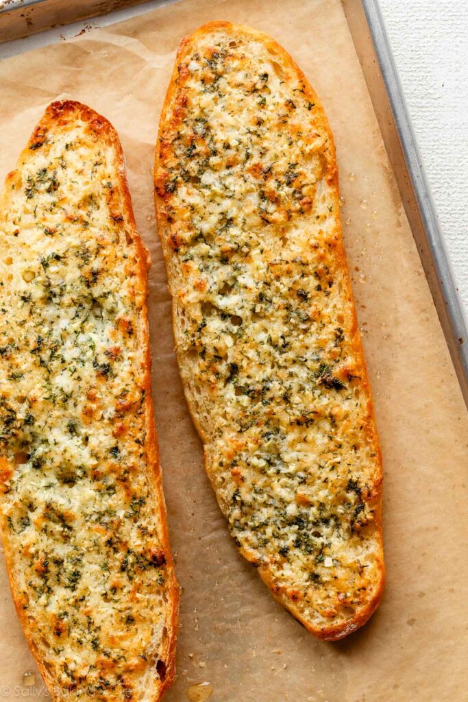 baked homemade garlic bread on parchment paper-lined baking sheet.