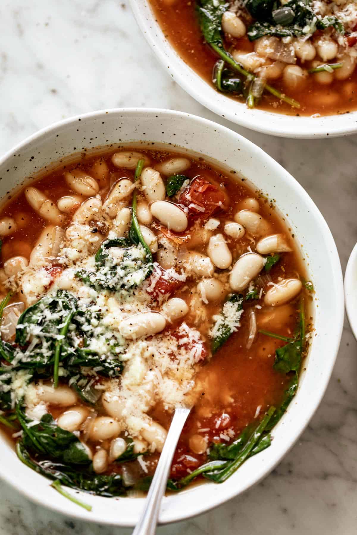 Soupe de Haricots Blancs au Parmesan et aux Épinards prête en 10 minutes est ma soupe préférée ! Faites une double portion et gardez beaucoup de restes pour le rush du dîner !