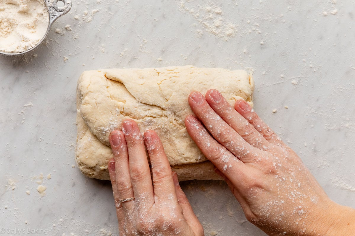 mains pliant la pâte vers le bas.