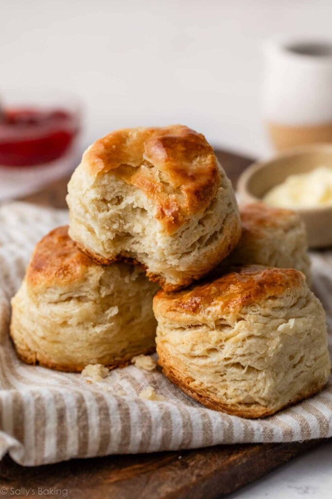 3 homemade biscuits in a pile on striped linen.