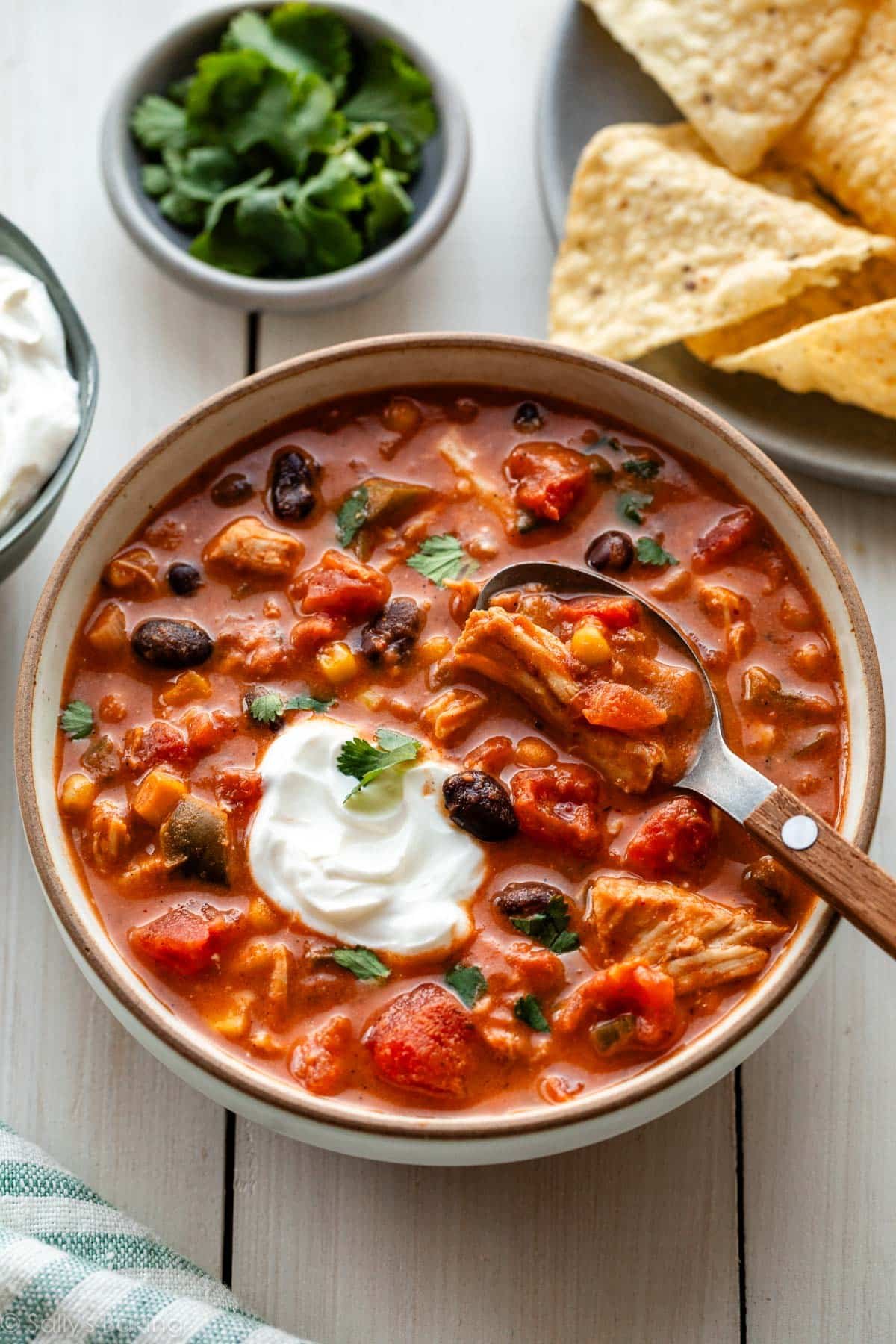 bowl of slow cooker chicken chili with sour cream on top.