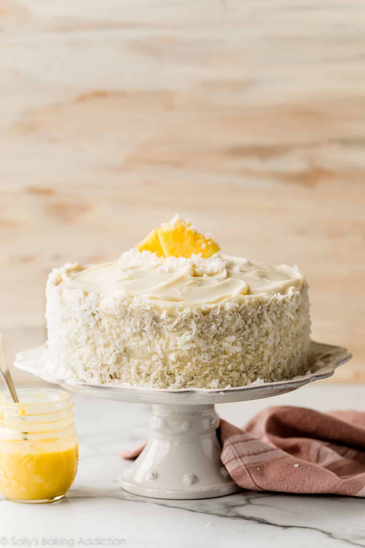 gâteau ananas noix de coco sur un support à gâteau blanc.