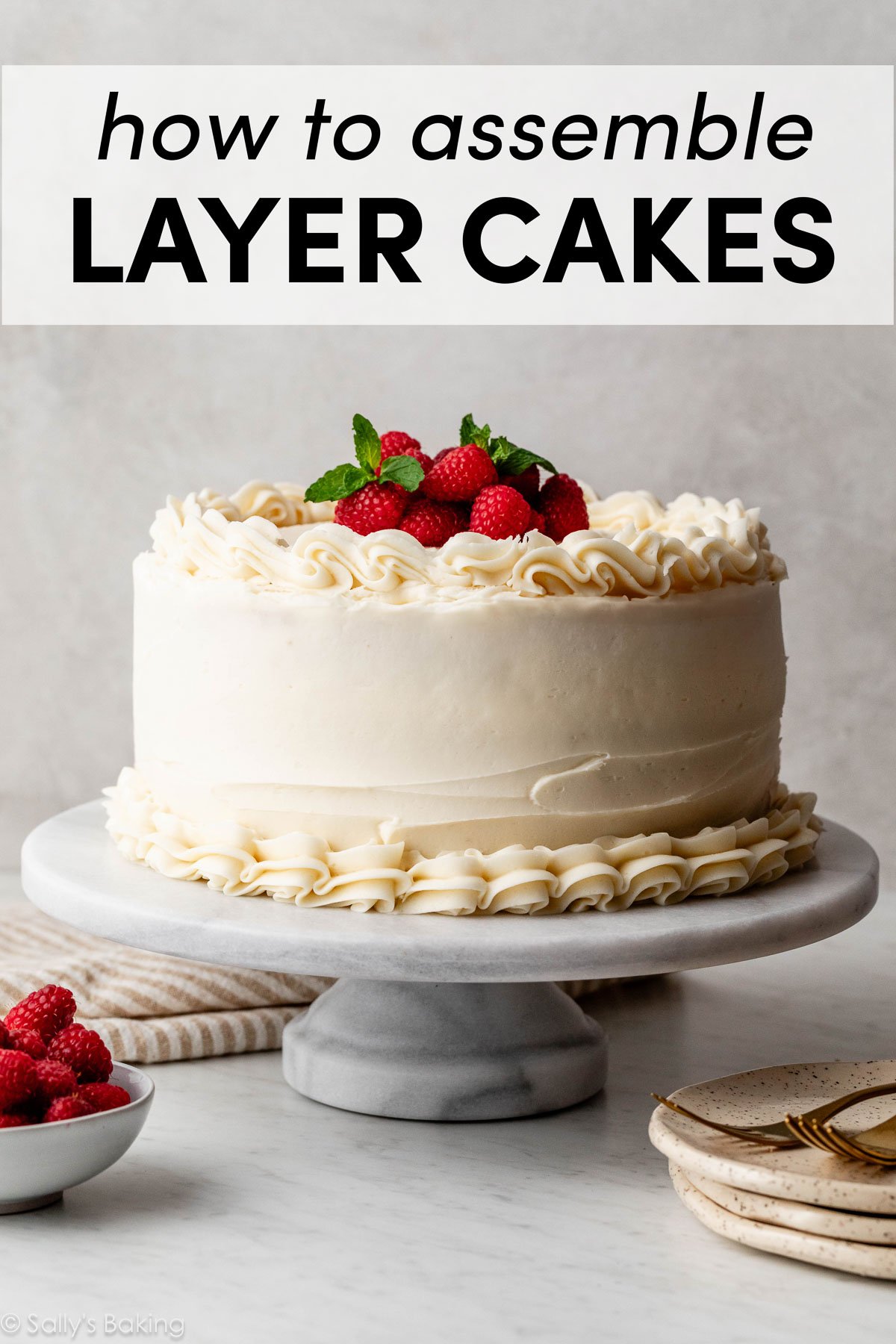 gâteau à étages vanille avec crème au beurre à la vanille et framboises fraîches et menthe sur le dessus.