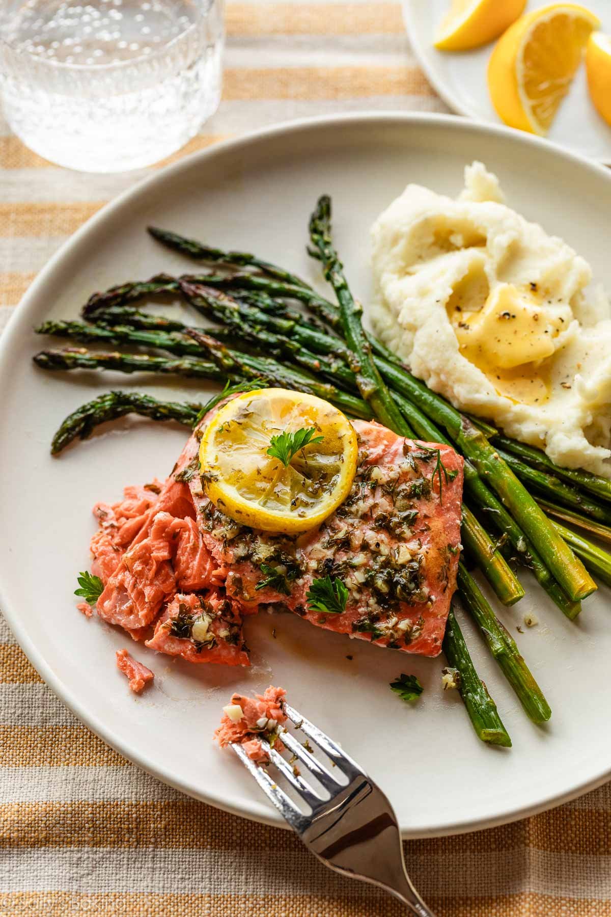 saumon à l'ail et au citron sur assiette avec asperges et purée de pommes de terre.