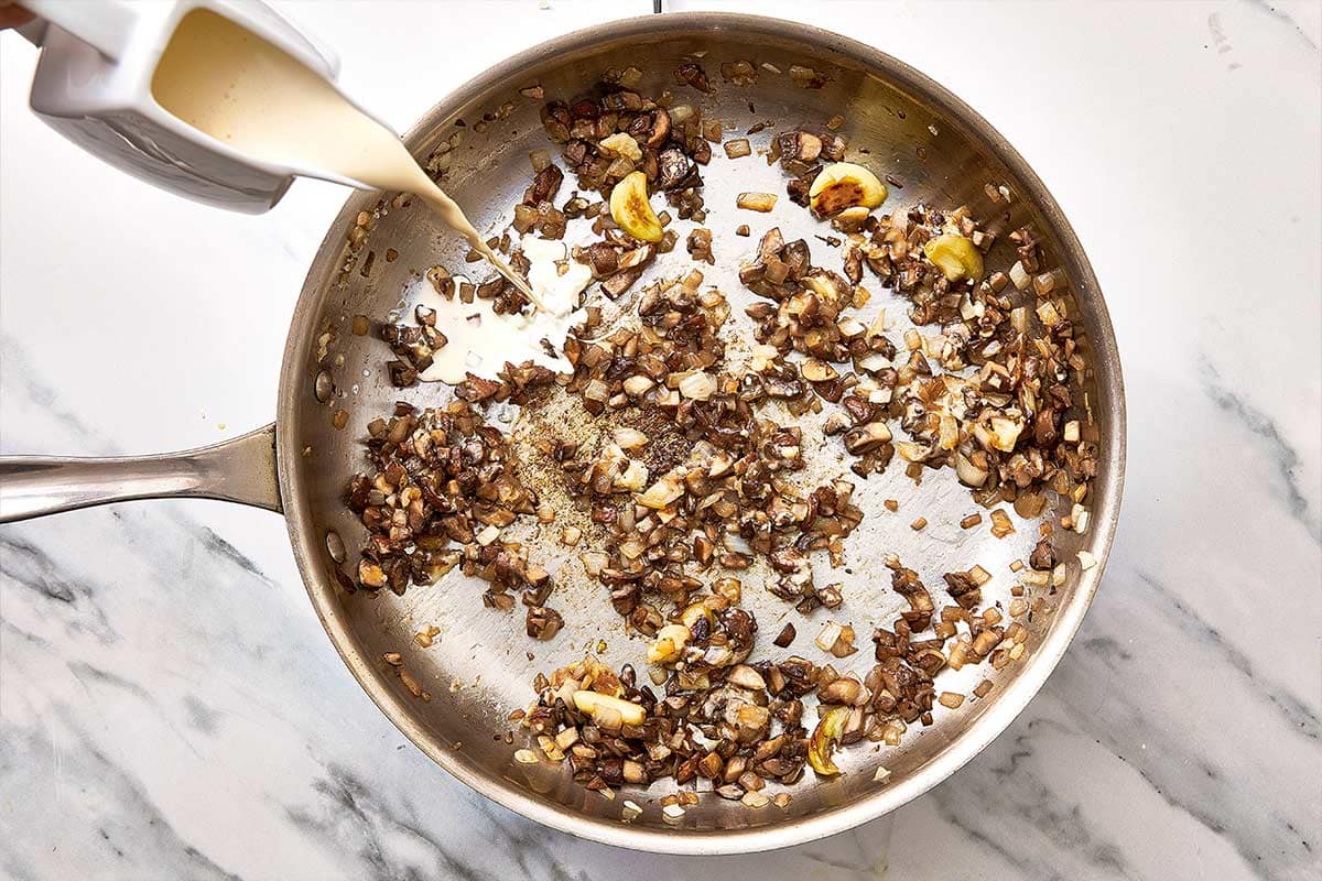 champignons, oignon et ail dans une poêle avec crème