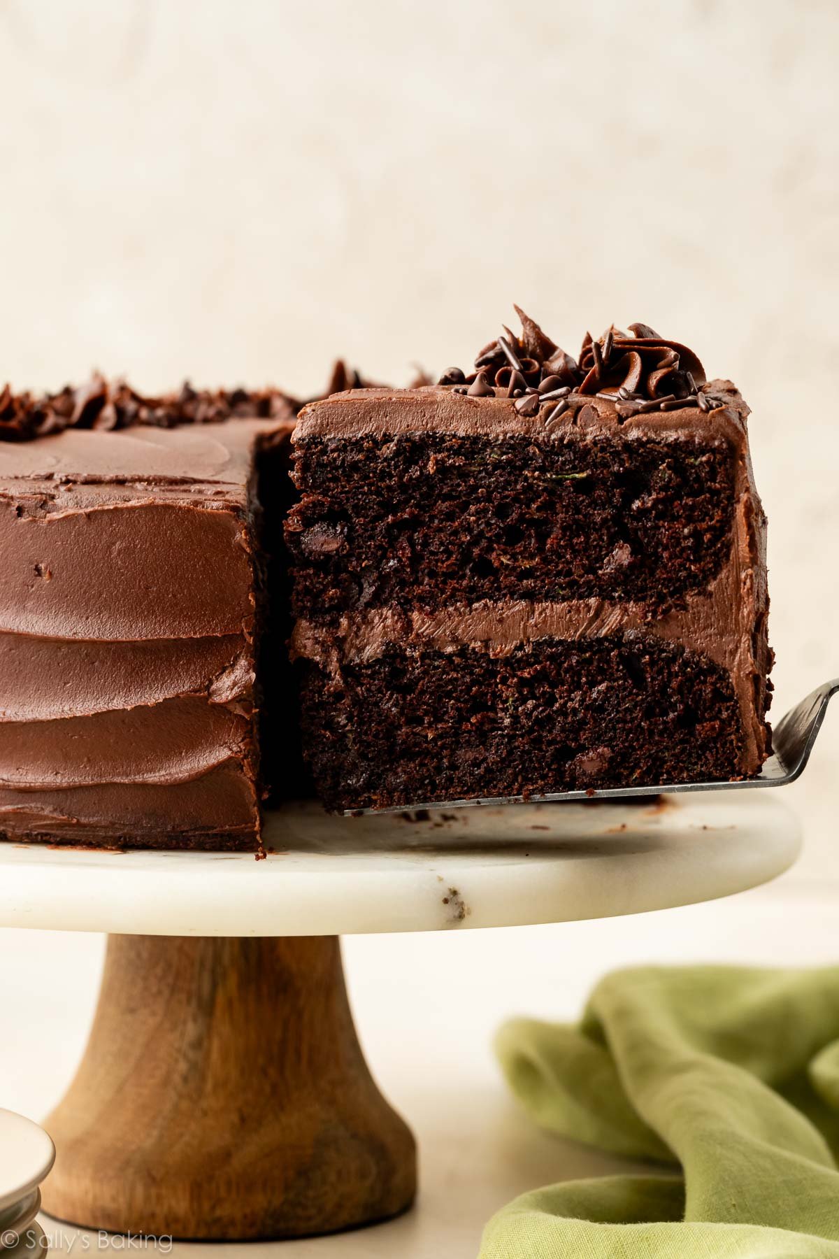 Un serveur de gâteau retirant une part d'un gâteau au chocolat et courgette.