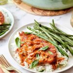 Plated Marry Me Chicken served over white rice with roasted green beans and fresh basil.