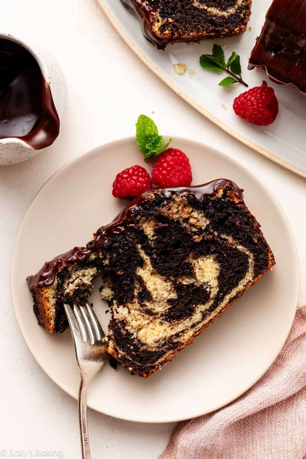 tranche de gâteau marbré avec glaçage sur une assiette beige.