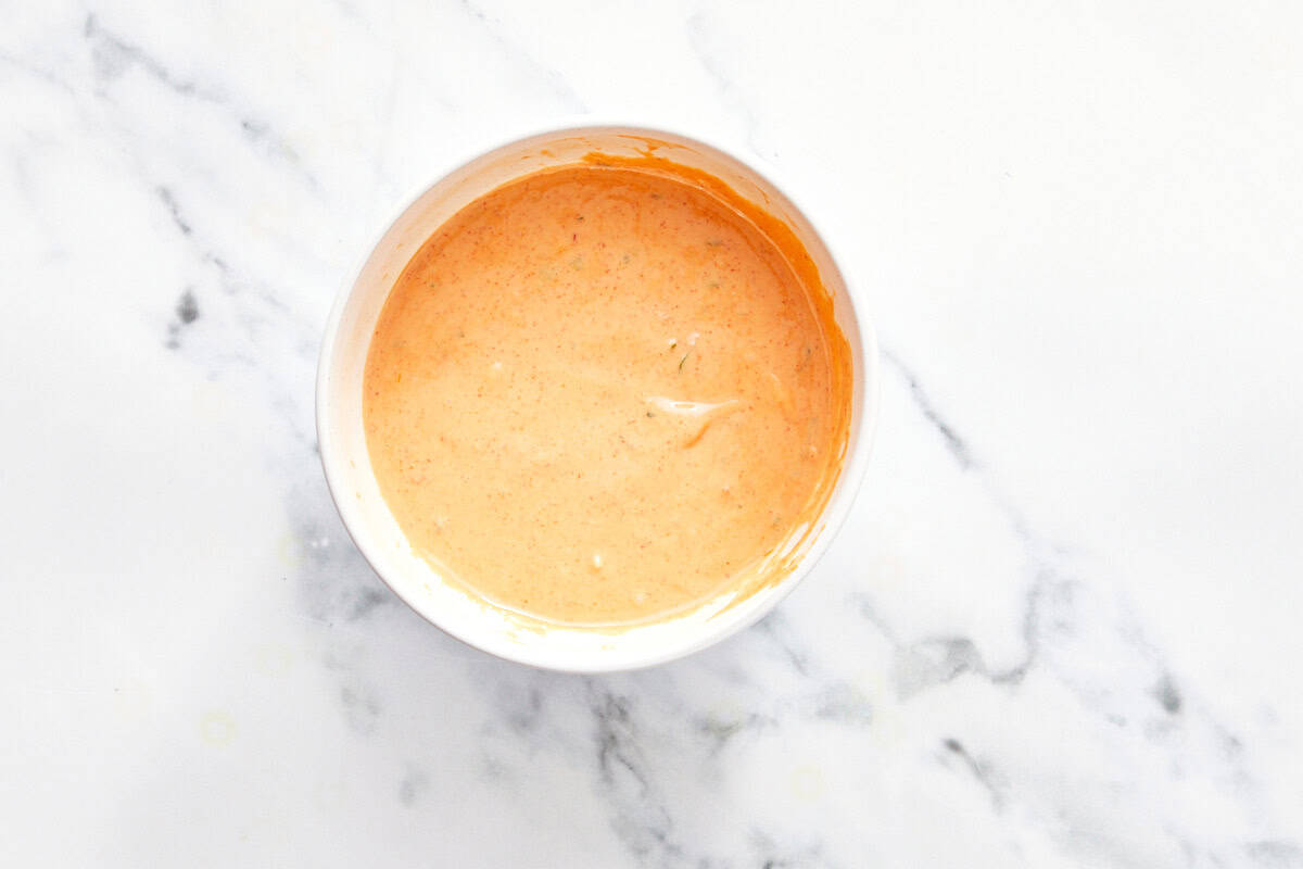 Bol de sauce Bang Bang crémeuse sur une surface en marbre.