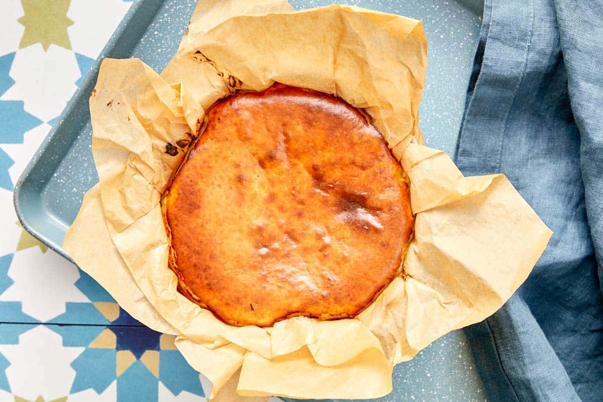 Cheesecake Basque fraîchement cuit dans du papier sulfurisé à l'intérieur d'un plat de cuisson