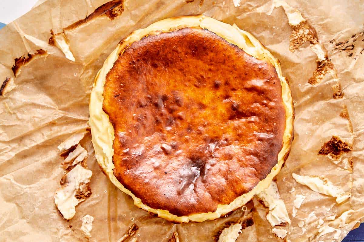 Cheesecake Basque avec un dessus caramélisé reposant sur du papier sulfurisé