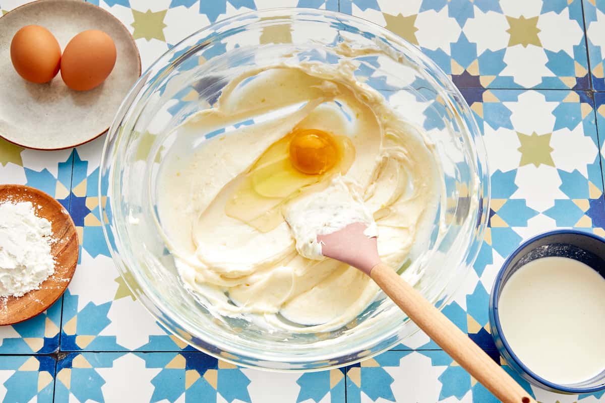 Œuf mélangé dans la pâte à cheesecake crémeuse