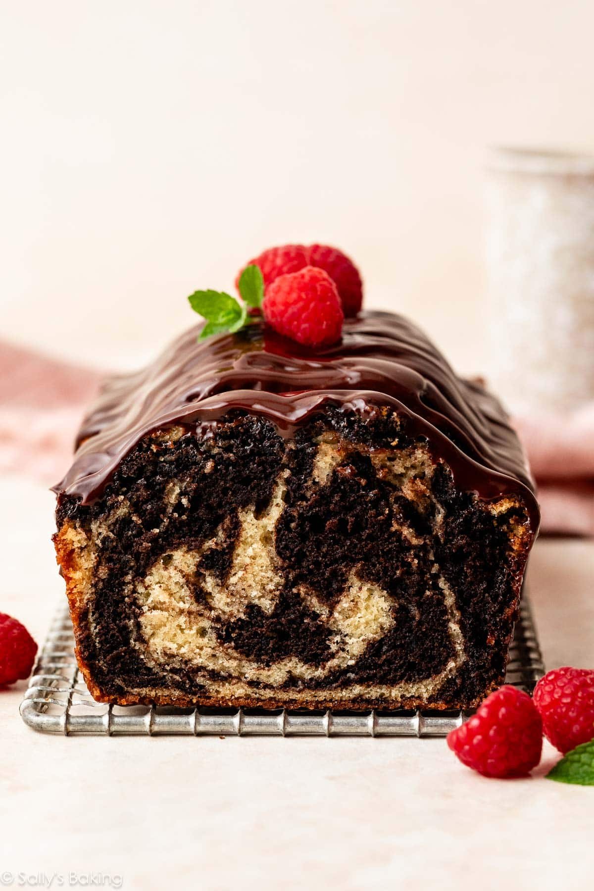 gâteau marbré avec ganache et framboises fraîches sur le dessus.