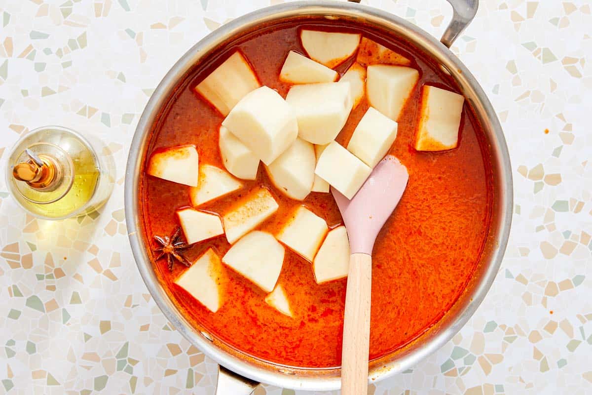 Pommes de terre ajoutées à un curry Massaman mijotant.