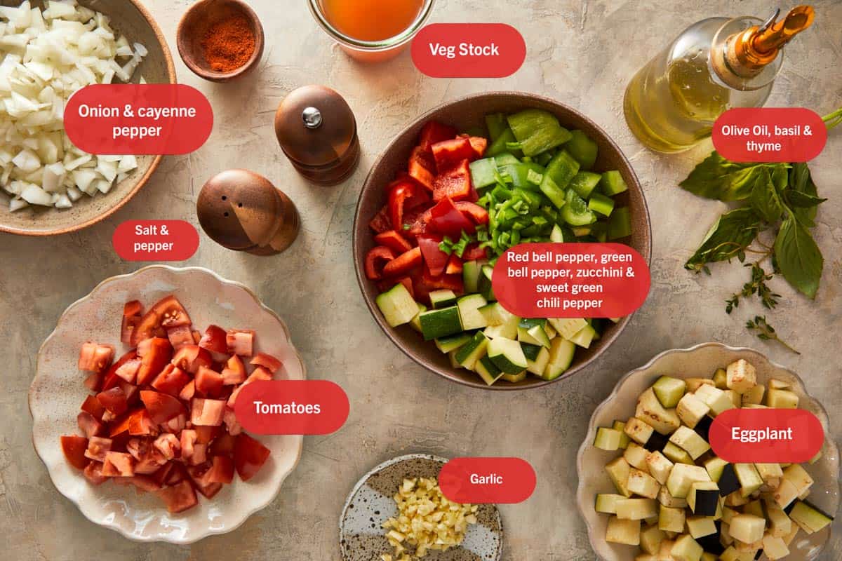 Ingrédients pour la Ratatouille, joliment disposés sur une table en bois.