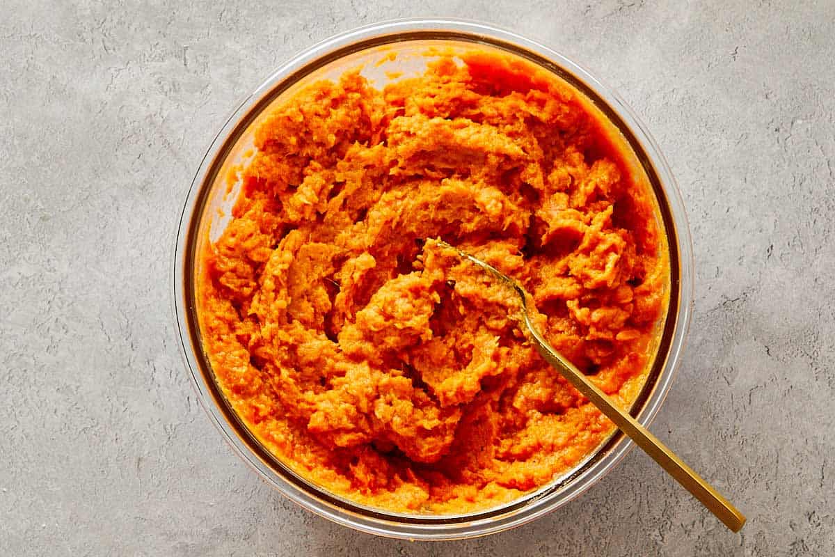 Bol en bois rempli de mélange de streusel aux noix de pécan fait de sucre brun, de beurre et de noix de pécan hachées.